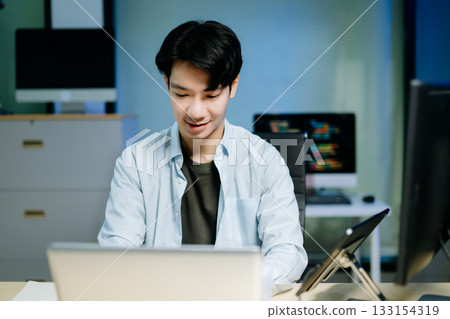 Asian software developer working late with code on screens, tablet, and phone. Concept of programming, tech lifestyle, Asian software developer working late with code on screens, tablet, and phone. Concept of programming, tech lifestyle, 133154319