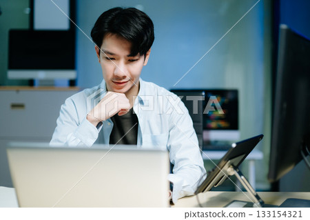 Asian software developer working late with code on screens, tablet, and phone. Concept of programming, tech lifestyle, Asian software developer working late with code on screens, tablet, and phone. Concept of programming, tech lifestyle, 133154321
