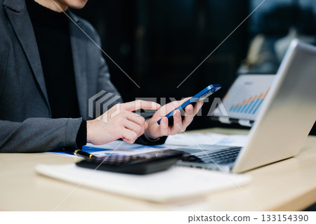 Confident businessman working on laptop, tablet and smartphone at her workplace Confident businessman working on laptop, tablet and smartphone at her workplace 133154390