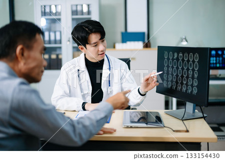Doctor discusses brain scan results with patient using screen and clipboard.  health care, neurology, diagnosis 133154430