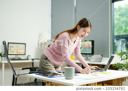 woman celebrates success while working on a tablet in a modern creative office, capturing achievement woman celebrates success while working on a tablet in a modern creative office, capturing achievement 133154781