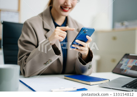 Business woman using smartphone and working on laptop computer  Woman freelancer online working 133154812