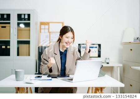 Asian business woman are delighted and happy with the work they do on their tablet, laptop and taking notes Asian business woman are delighted and happy with the work they do on their tablet, laptop and taking notes 133154824
