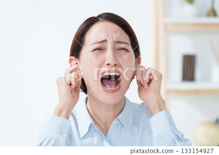 Woman covering her ears from the noise 133154927