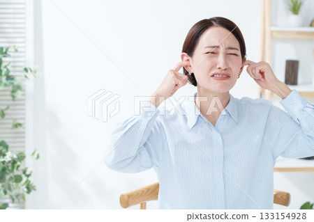 Woman covering her ears from the noise 133154928