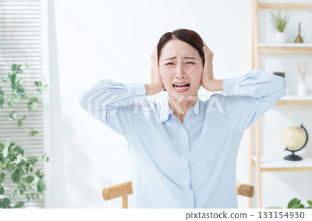 Woman covering her ears from the noise Woman covering her ears from the noise 133154930