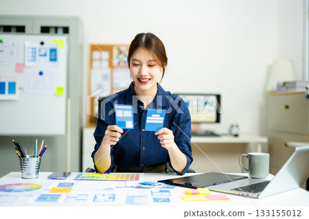 designer holds wireframe cards while planning UX/UI in a creative office, showcasing innovation, technology designer holds wireframe cards while planning UX/UI in a creative office, showcasing innovation, technology 133155012