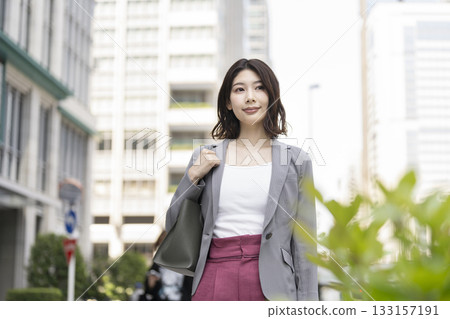 A business woman in her 30s walking down the street 133157191