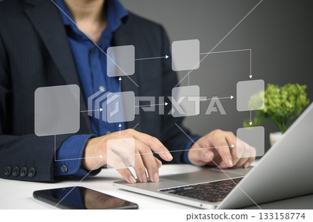 Business professional using a laptop to create a virtual flowchart, demonstrating digital technology for process organization and optimization. Business professional using a laptop to create a virtual flowchart, demonstrating digital technology for process organization and optimization. 133158774