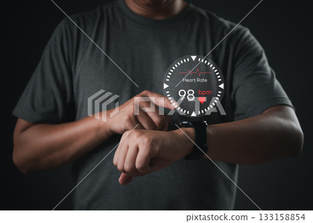 Man using smartwatch with heart rate monitor interface, representing wearable health technology and real-time fitness tracking. digital wellness solutions mobile health app. Man using smartwatch with heart rate monitor interface, representing wearable health technology and real-time fitness tracking. digital wellness solutions mobile health app. 133158854