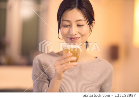 A middle-aged woman having dinner while drinking beer A middle-aged woman having dinner while drinking beer 133158987
