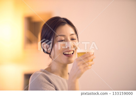 中年婦女一邊吃晚餐一邊喝啤酒 中年婦女一邊吃晚餐一邊喝啤酒 133159000
