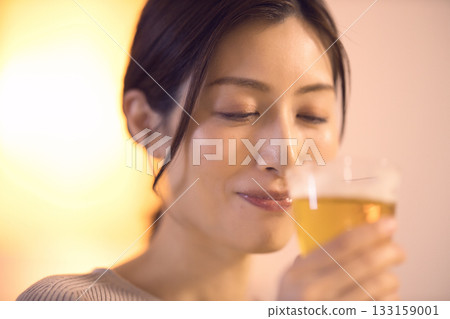 中年婦女一邊吃晚餐一邊喝啤酒 中年婦女一邊吃晚餐一邊喝啤酒 133159001