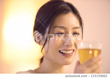 中年婦女一邊吃晚餐一邊喝啤酒 133159002