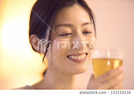 Middle-aged woman eating dinner while drinking beer Middle-aged woman eating dinner while drinking beer 133159230