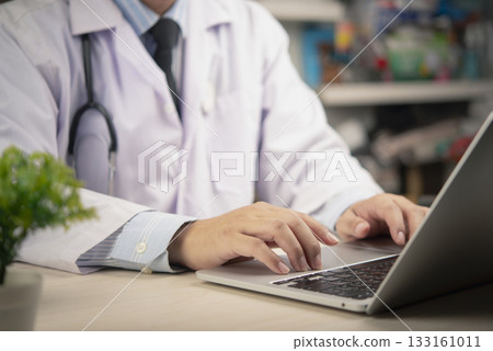 medical professional at a desk with a laptop, using modern technology to enhance productivity and efficiency in managing patient information and health data 133161011