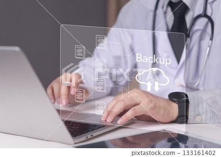 Physician working on laptop with virtual screen displaying cloud backup icon, concept medical data protection, electronic health records, cybersecurity healthcare, future healthcare solutions. 133161402