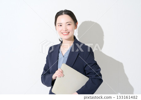 一位日本女性在白色背景下拿著筆記型電腦。 133161482
