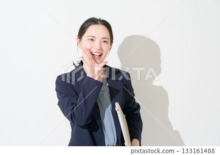 一位日本女性在白色背景下拿著筆記型電腦。 133161488