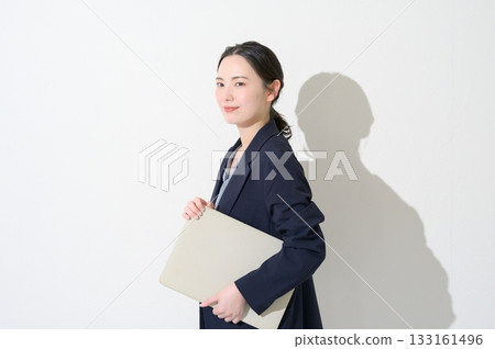 Japanese woman holding a laptop on a white background Japanese woman holding a laptop on a white background 133161496
