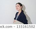 Japanese woman holding a laptop on a white background 133161502
