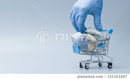 Dentist Hand with Glove Holding Dental Casts in Shopping Cart Dentist Hand with Glove Holding Dental Casts in Shopping Cart 133161887