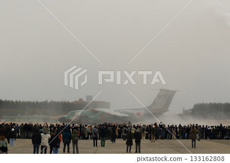 An EC-1 electronic warfare aircraft passes through a water cannon at a retirement ceremony. 133162808