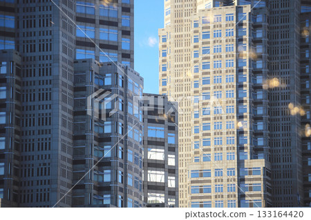 Mid-rise and high-rise buildings in the city center with a glimpse of blue sky and clouds Mid-rise and high-rise buildings in the city center with a glimpse of blue sky and clouds 133164420