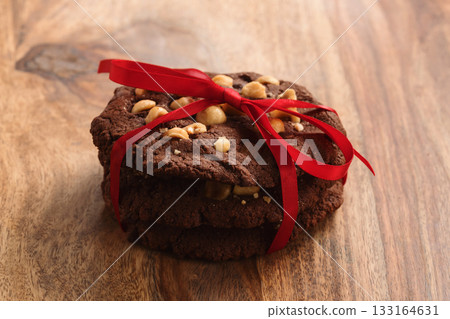 homemade chocolate cookies with hazelnuts tied with ribbon on wood table homemade chocolate cookies with hazelnuts tied with ribbon on wood table 133164631