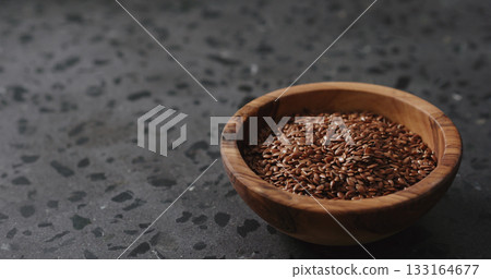 flaxseed in olive bowl on terrazzo countertop with copy space 133164677