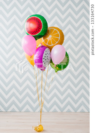 Colorful Fruit Balloons On Floor Against Zigzag Wall 133164730