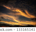 橘色的夕陽籠罩著天空，雲彩繚繞。 133165141