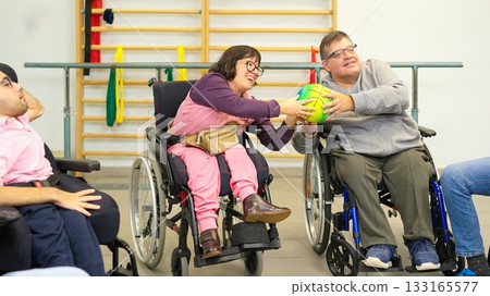 Adults with physical disabilities playing ball during therapy session Adults with physical disabilities playing ball during therapy session 133165577