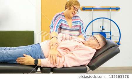 Physiotherapist working on patient arm during treatment session Physiotherapist working on patient arm during treatment session 133165578