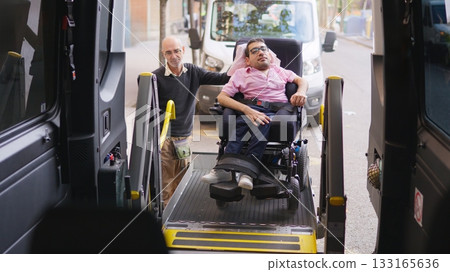 Man assisting wheelchair user entering accessible transport van Man assisting wheelchair user entering accessible transport van 133165636