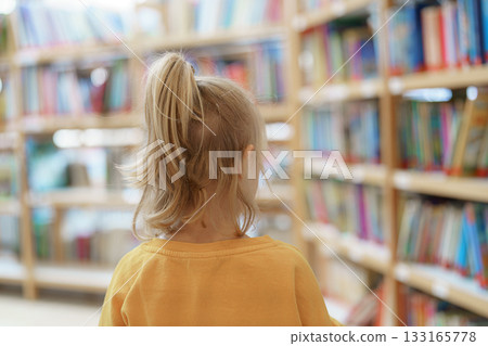 girl looking for books in library 133165778