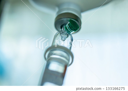 Close up medical intravenous IV drip in hospital background Close up medical intravenous IV drip in hospital background 133166275