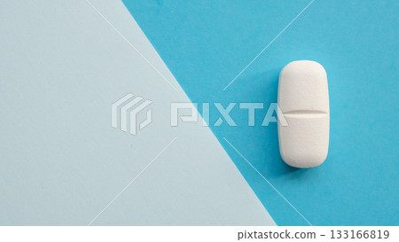 White medicine pill tablet on blue and white background 133166819