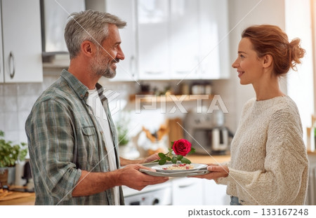 Mature couple sharing romantic breakfast with red rose Mature couple sharing romantic breakfast with red rose 133167248