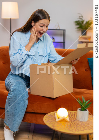 Happy woman girl shopper unpacking cardboard box delivery parcel online shopping purchase at home Happy woman girl shopper unpacking cardboard box delivery parcel online shopping purchase at home 133167481