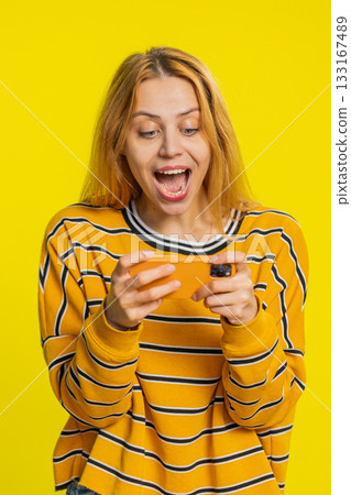 Happy woman playing racing drive simulator shooter video games on smartphone celebrate victory win Happy woman playing racing drive simulator shooter video games on smartphone celebrate victory win 133167489