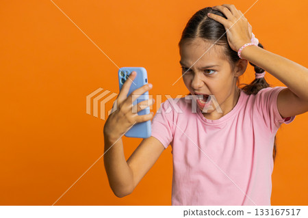 Upset sad child girl use smartphone play game loses loss fail unlucky news bad lottery result crisis Upset sad child girl use smartphone play game loses loss fail unlucky news bad lottery result crisis 133167517