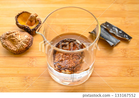 Dried shiitake mushrooms, a measuring cup, and water Dried shiitake mushrooms, a measuring cup, and water 133167552