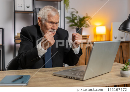 Angry senior freelancer businessman in suit making webcam laptop online video call at home office Angry senior freelancer businessman in suit making webcam laptop online video call at home office 133167572