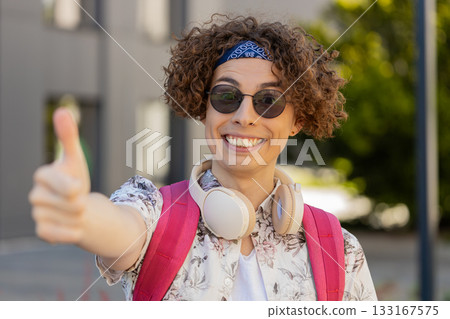 Happy young man tourist showing thumbs up like sign positive something good positive feedback 133167575