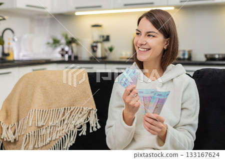 Young woman counts hryvnia money cash plans invest bonus and salary dreams of purchase future goal Young woman counts hryvnia money cash plans invest bonus and salary dreams of purchase future goal 133167624