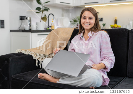 Young woman freelancer finishes tasks closes laptop smiles leans back takes break feels happy relief 133167635