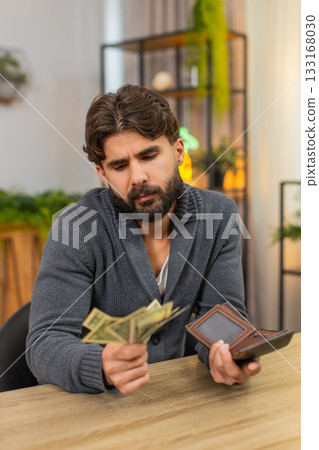 Indian man looks in wallet sees only coins unhappy mood debt overdue bills low salary and low profit Indian man looks in wallet sees only coins unhappy mood debt overdue bills low salary and low profit 133168030