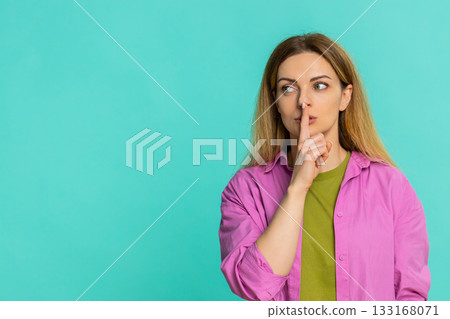 Woman placing finger on lips asking for silence gesture to keep secret or stay quiet with calm look Woman placing finger on lips asking for silence gesture to keep secret or stay quiet with calm look 133168071