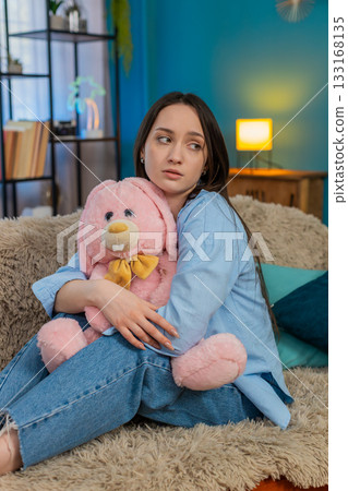 Woman on sofa hugging plush bunny feeling lonely romantic missing beloved tenderness, divorce 133168135